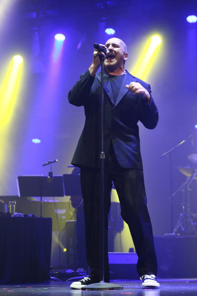 picture of rob l as phill collins on stage singing